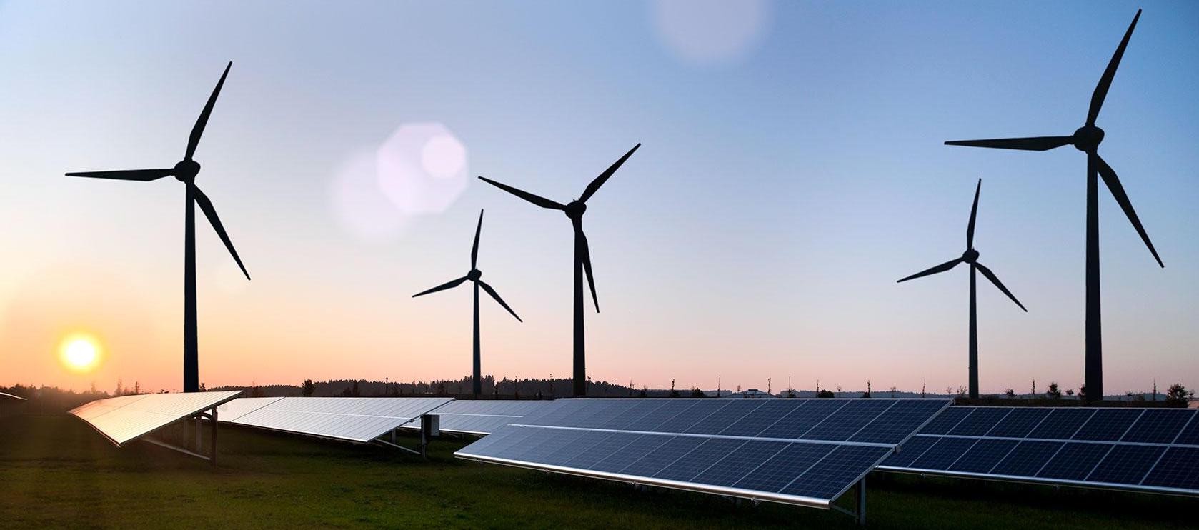 wind turbines and solar panels at dusk