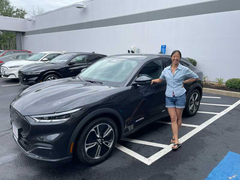 Woman next to her Mustang Mach-E