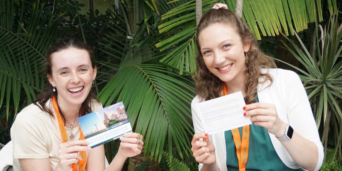 Amanda and Tina holding decarbonization postcards at spring meeting 2026