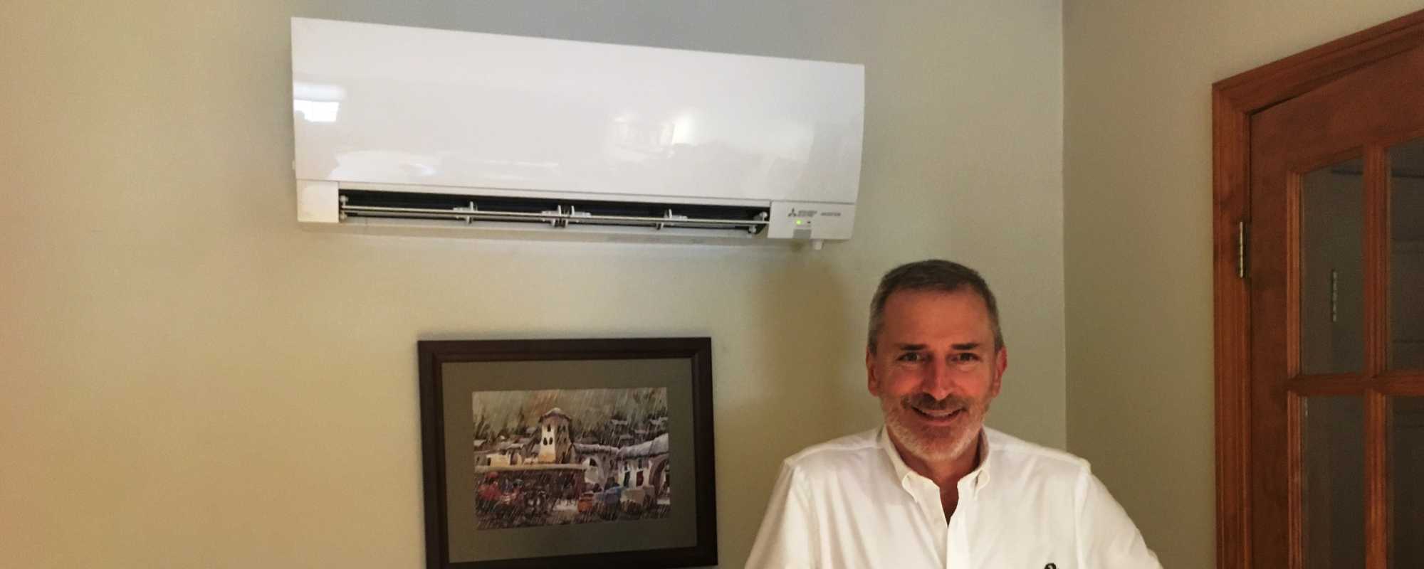 member standing in front of a heat pump